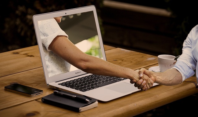 creepty arm reaches out of laptop to shake poor smucks hand